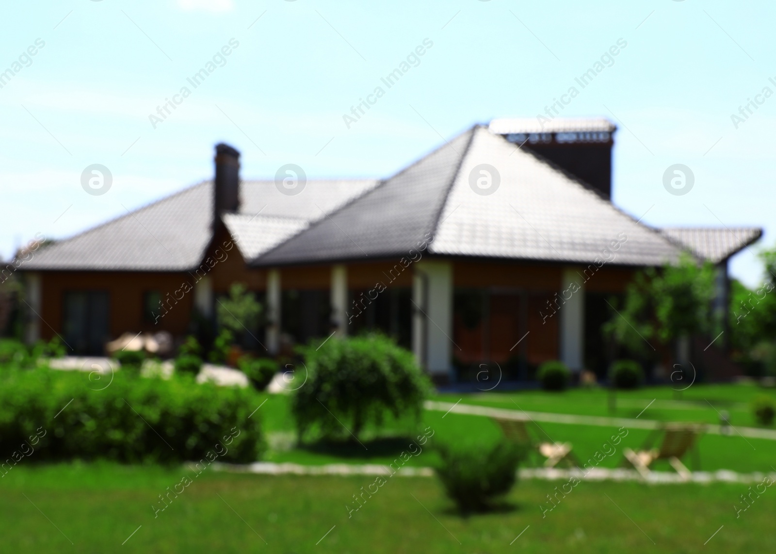 Photo of Blurred view of modern house and beautiful garden on sunny day