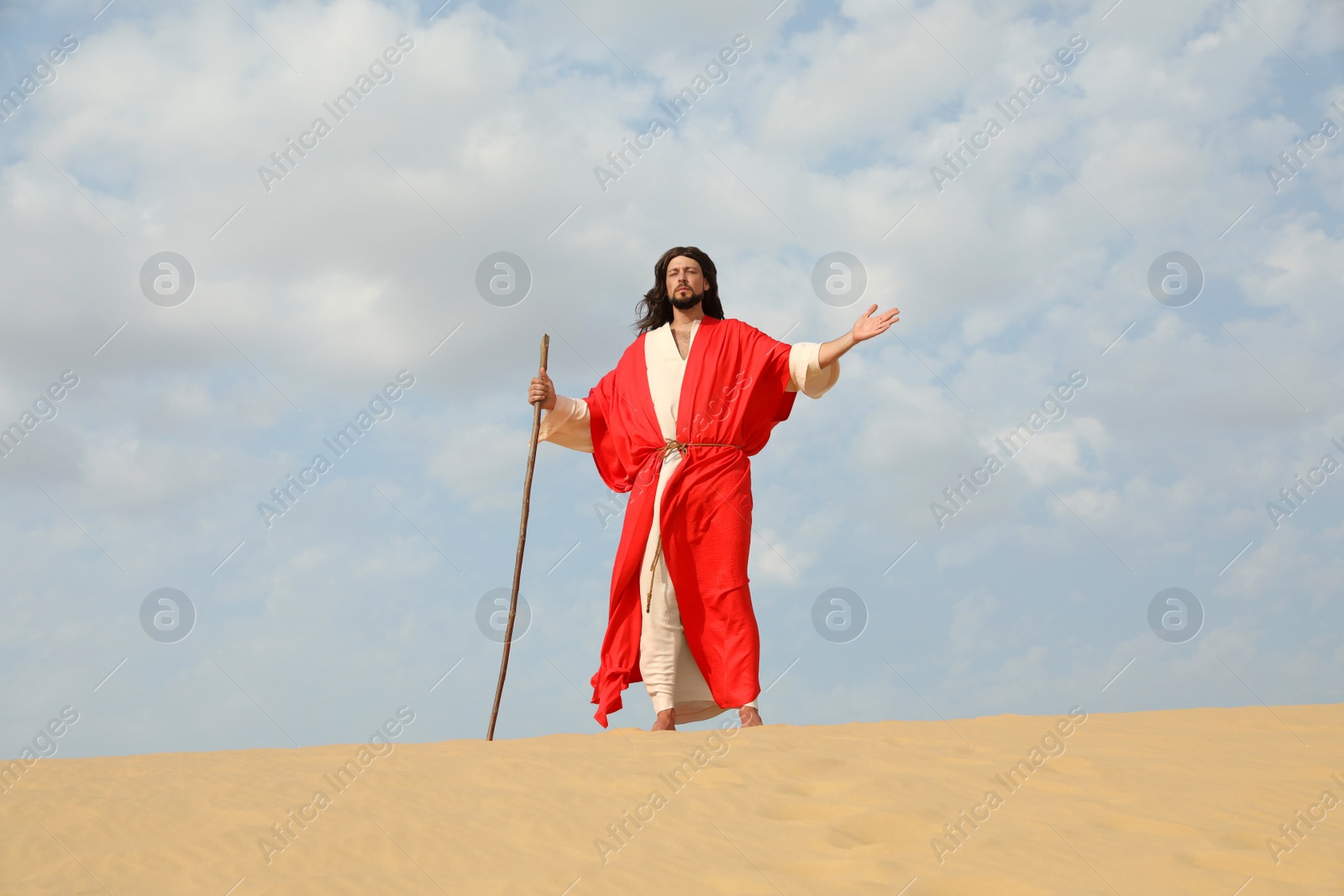 Photo of Jesus Christ walking with stick in desert