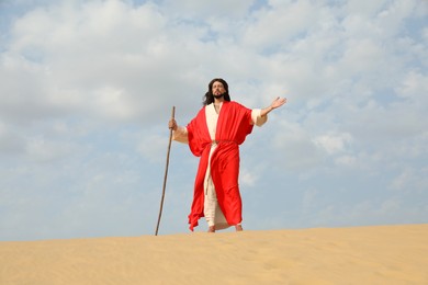 Photo of Jesus Christ walking with stick in desert