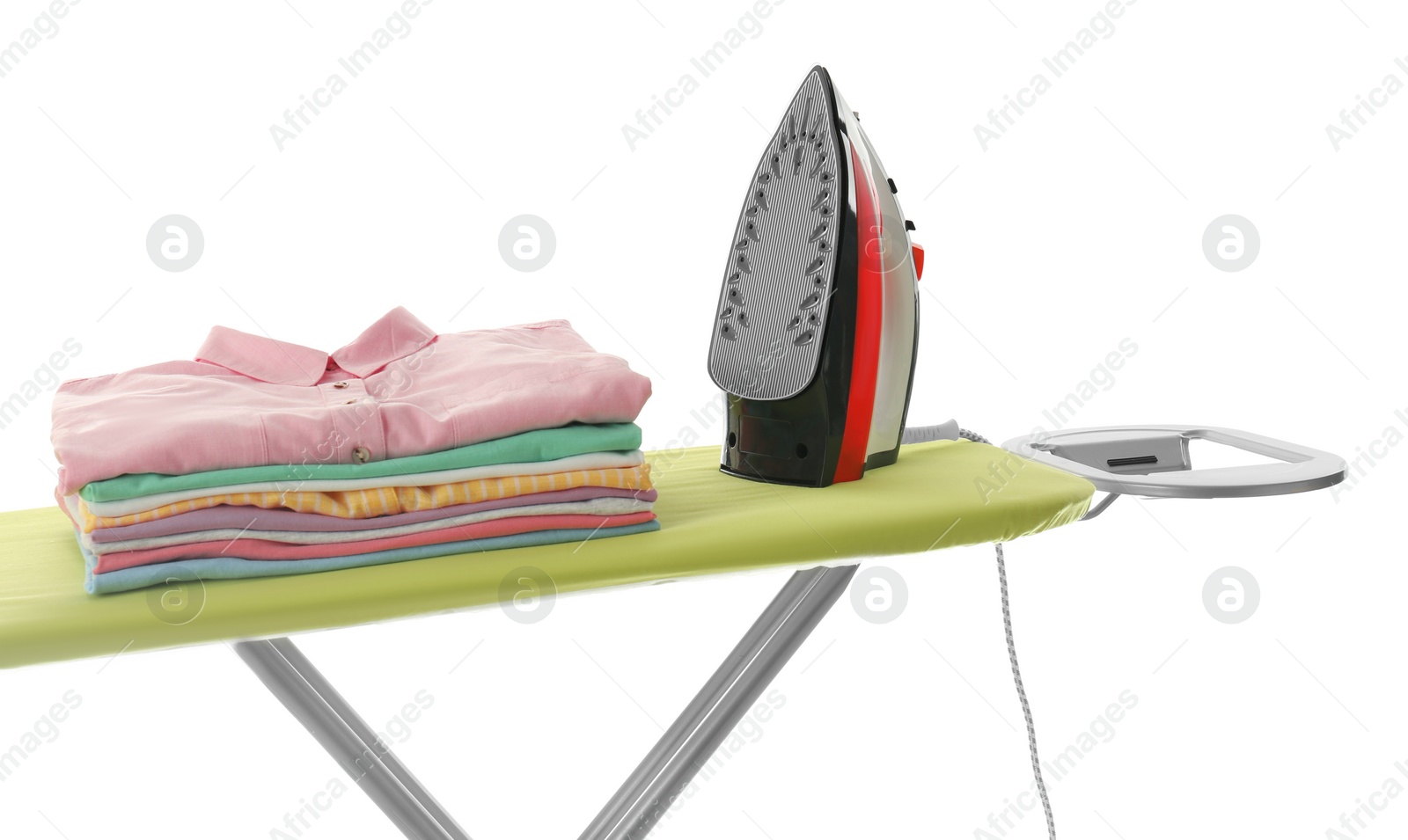 Photo of Board with modern iron and clean laundry on white background