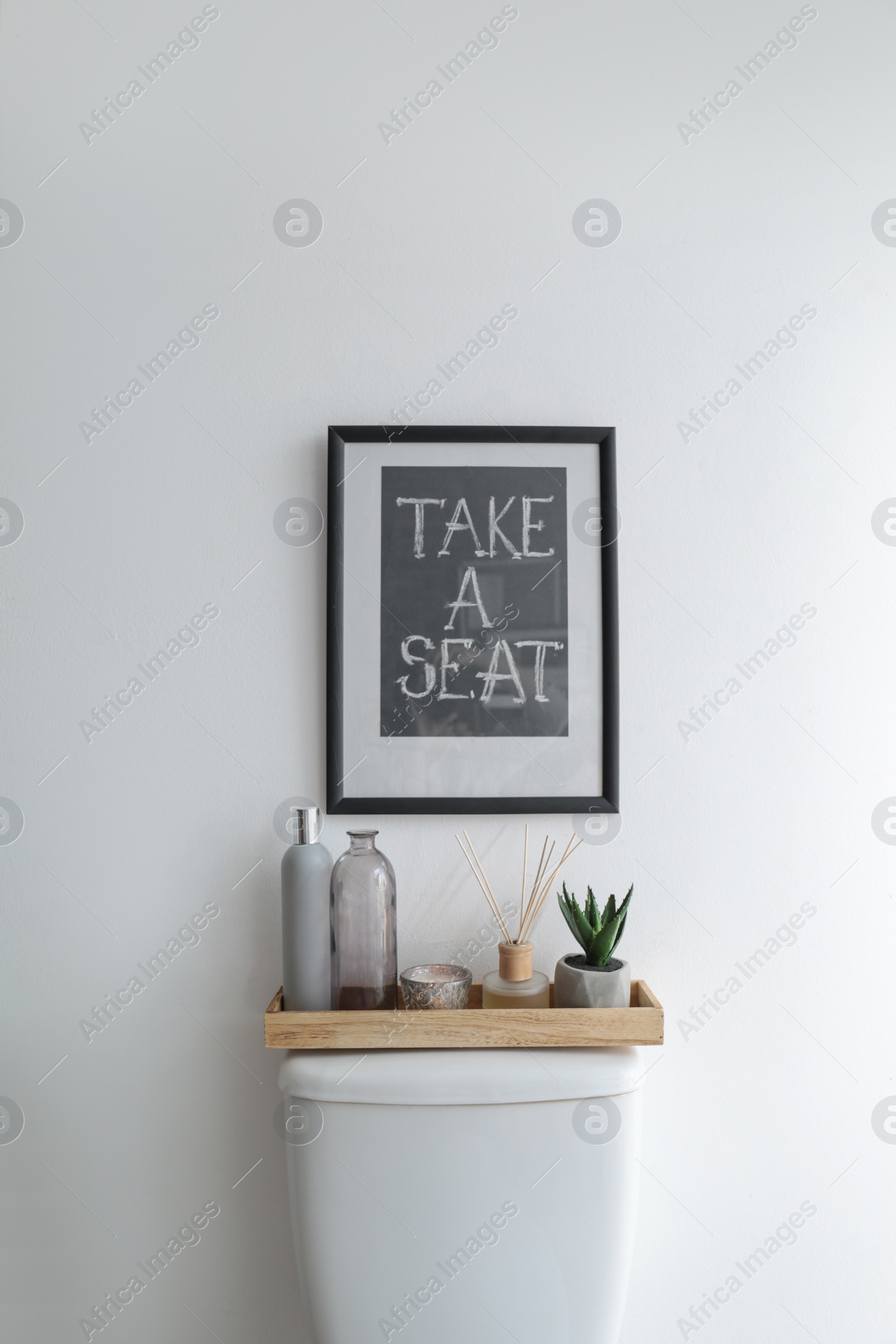 Photo of Decor elements, necessities and toilet bowl near white wall. Bathroom interior