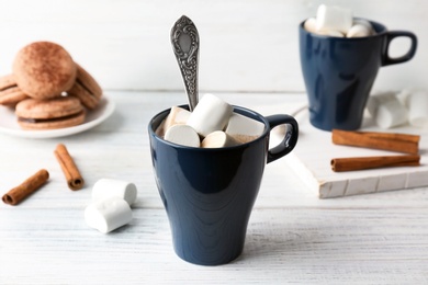 Photo of Cup with delicious hot cocoa drink and marshmallows on table