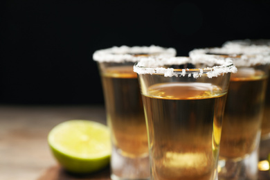 Photo of Mexican Tequila shots with salt on table, closeup