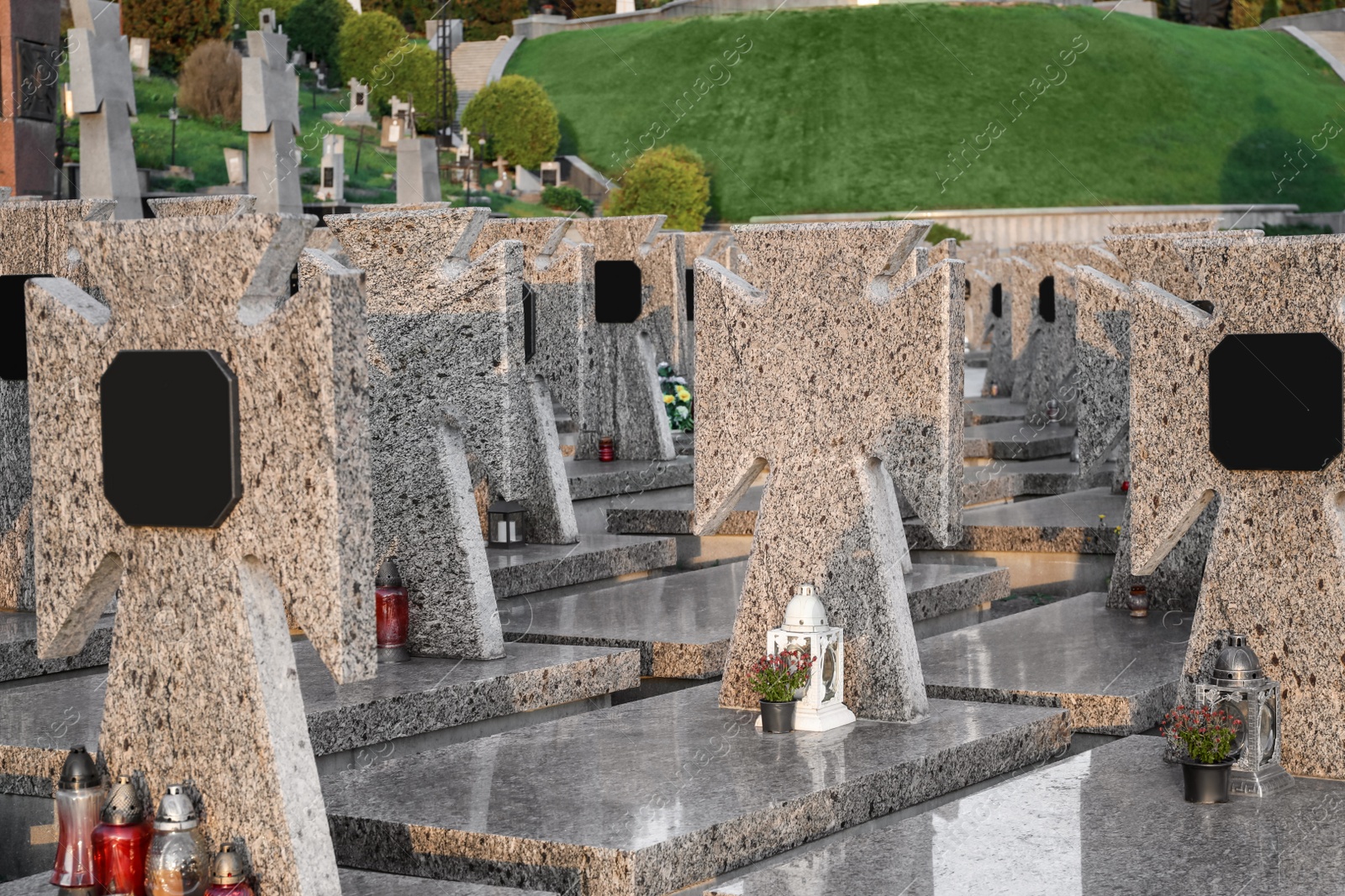 Photo of Many granite tombstones on cemetery. Funeral ceremony