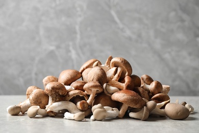 Photo of Heap of fresh wild mushrooms on light grey table