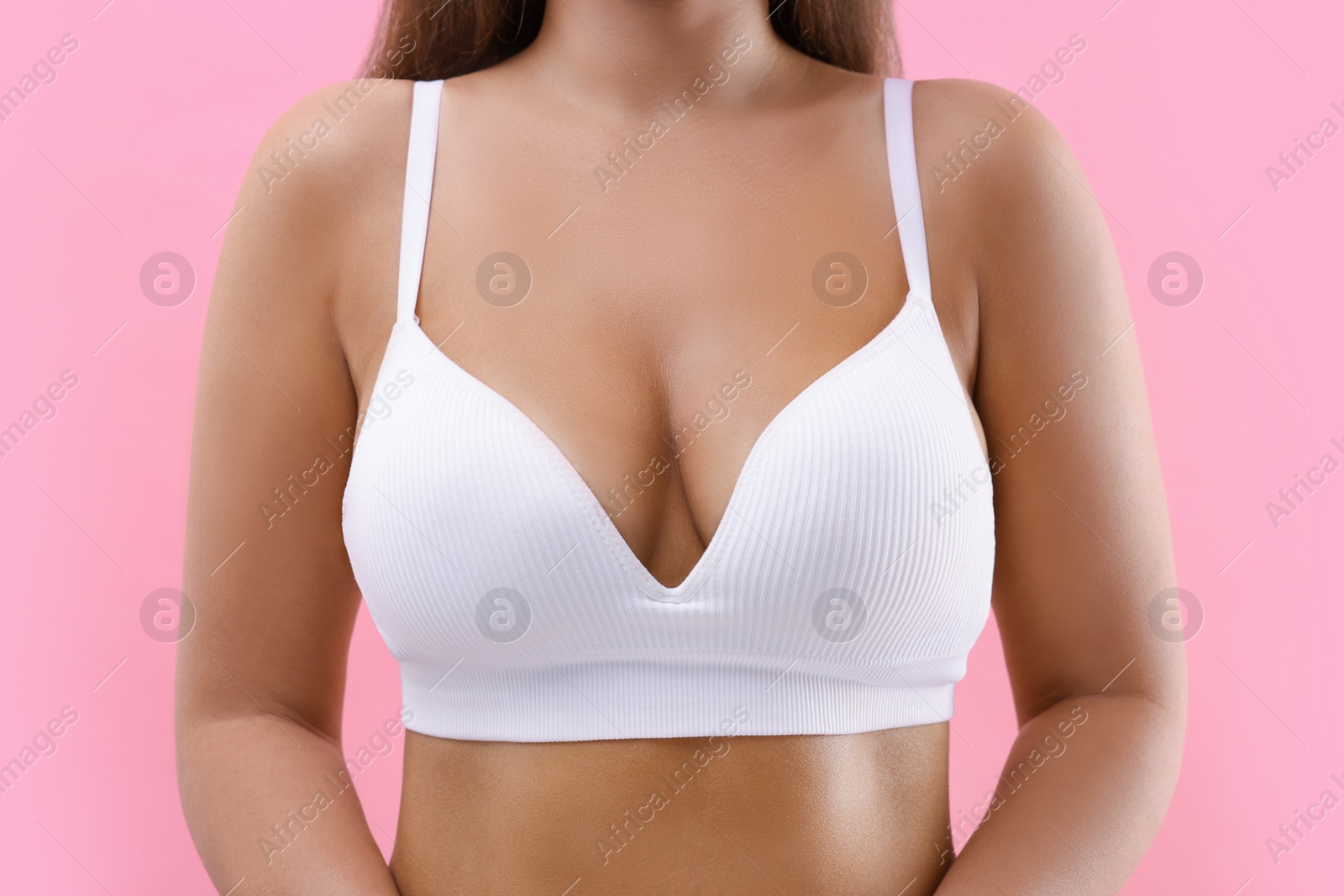 Photo of Woman with beautiful breast on pink background, closeup