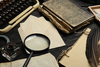 Photo of Composition with different vintage items on black wooden table. Detective's workplace