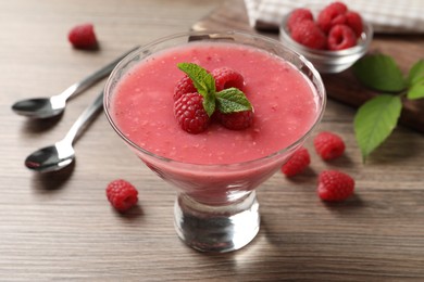 Delicious raspberry mousse with mint on wooden table