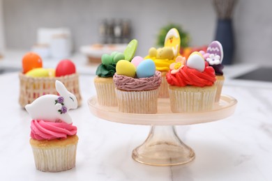 Tasty cupcakes with Easter decor on white marble table