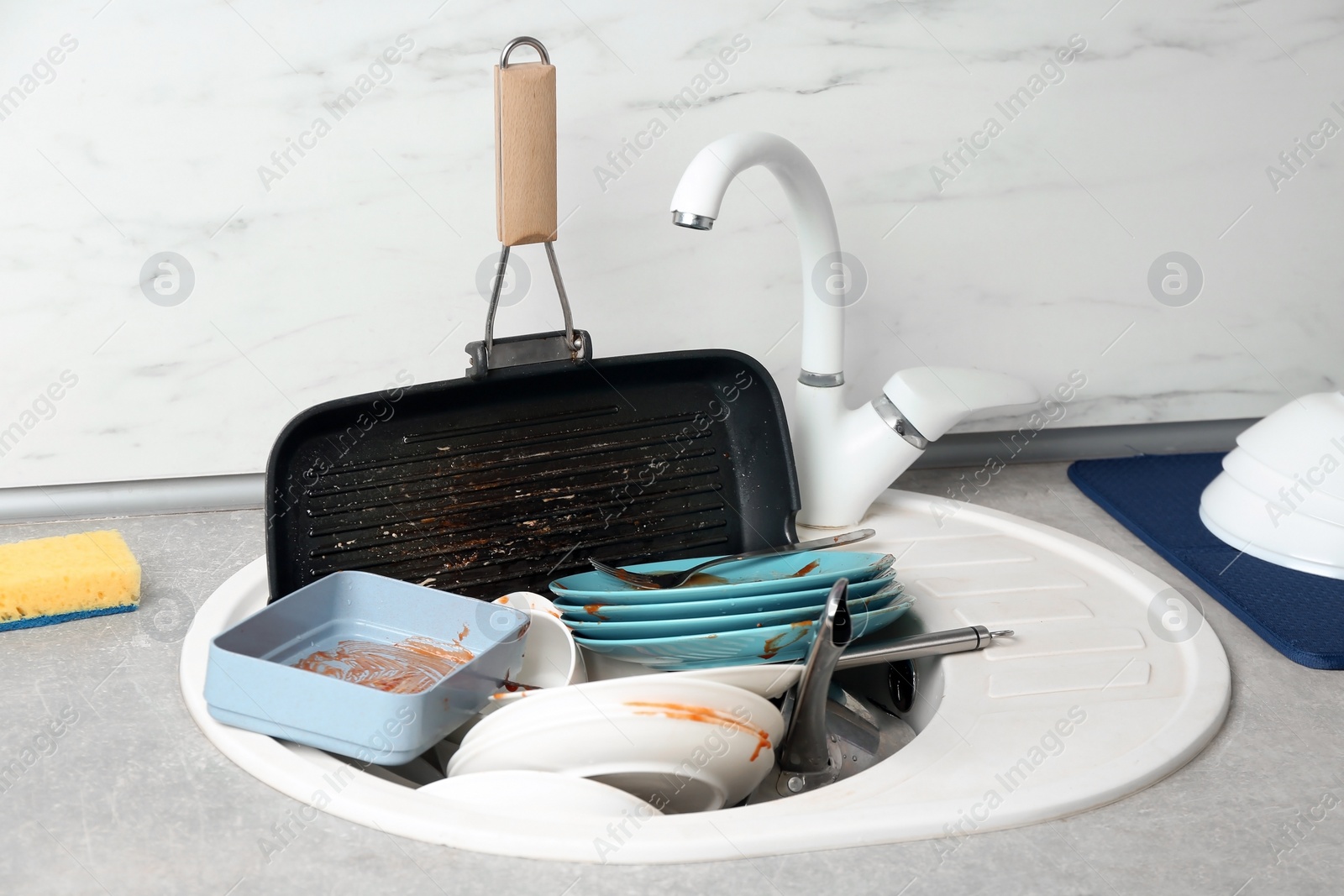 Photo of Messy pile of dirty dishes in sink