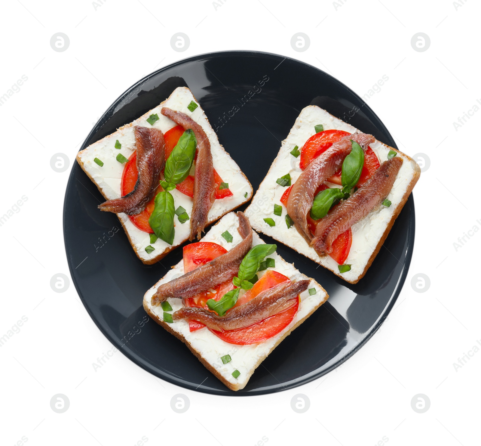 Photo of Delicious sandwiches with cream cheese, anchovies, tomatoes and basil on white background, top view