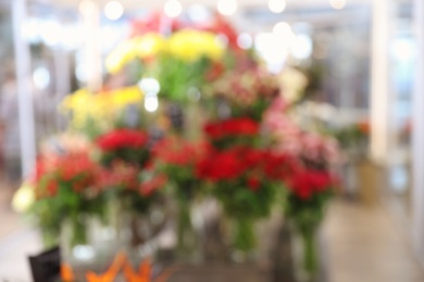 Photo of Blurred view of beautiful flowers in shop. Florist's workplace