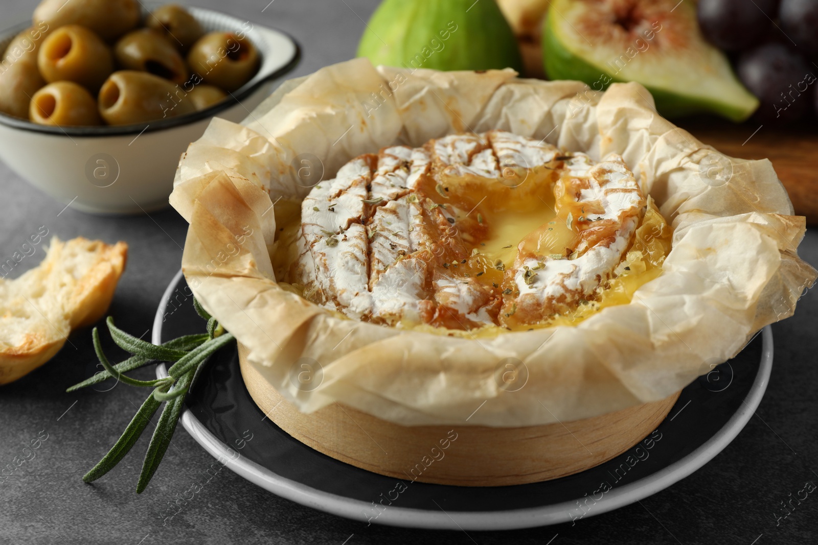 Photo of Tasty baked brie cheese on grey table, closeup