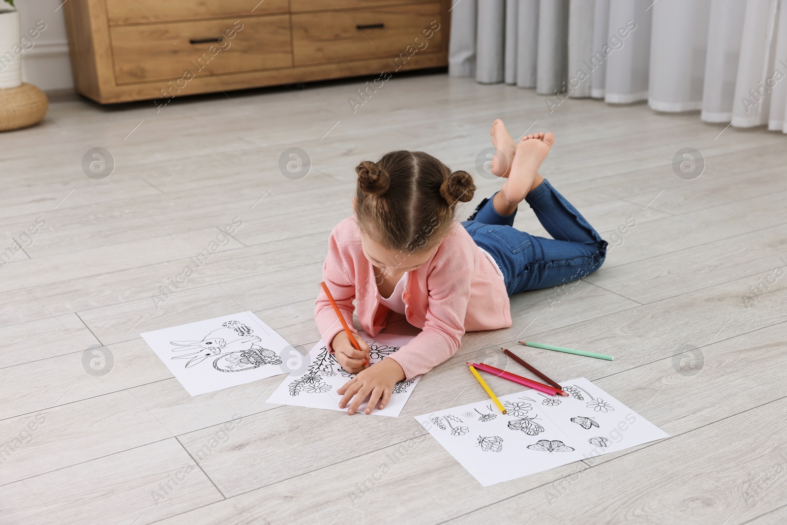 Photo of Cute little girl coloring on warm floor at home. Heating system