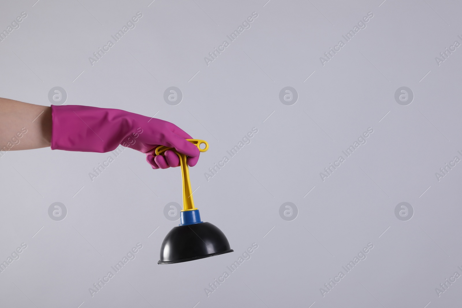 Photo of Woman holding plunger on light grey background, closeup. Space for text