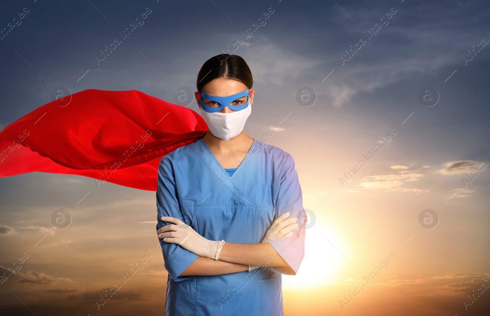 Image of Medical workers fighting with dangerous diseases. Doctor dressed as superhero posing against sky