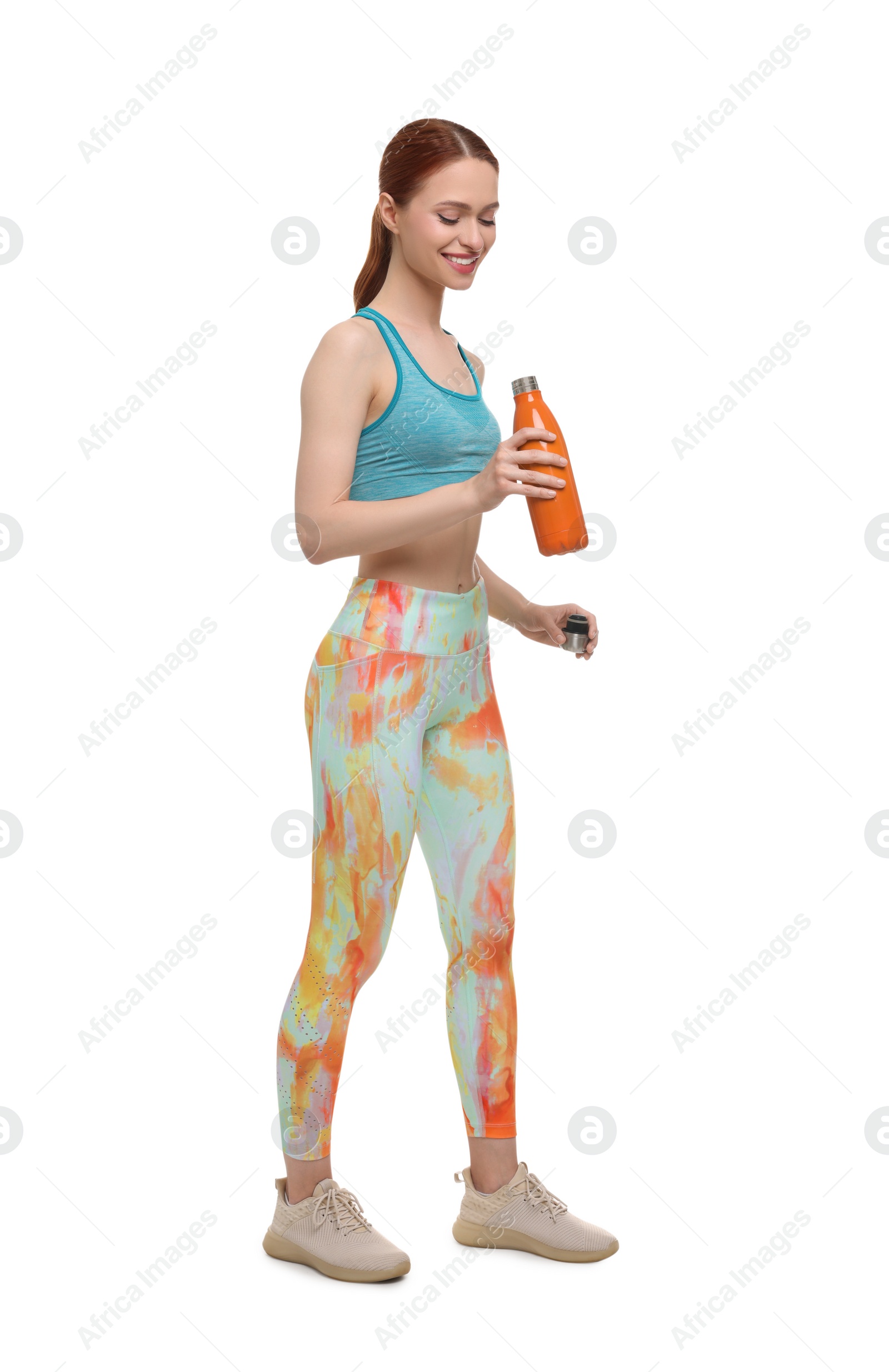 Photo of Young woman in sportswear with thermo bottle on white background