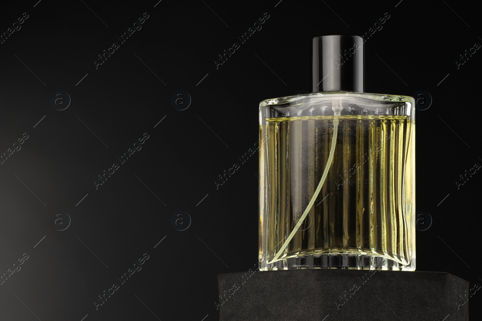 Photo of Luxury men`s perfume in bottle against dark background, space for text