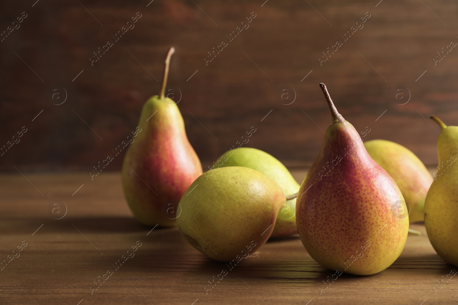 Photo of Ripe pears on wooden table. Space for text