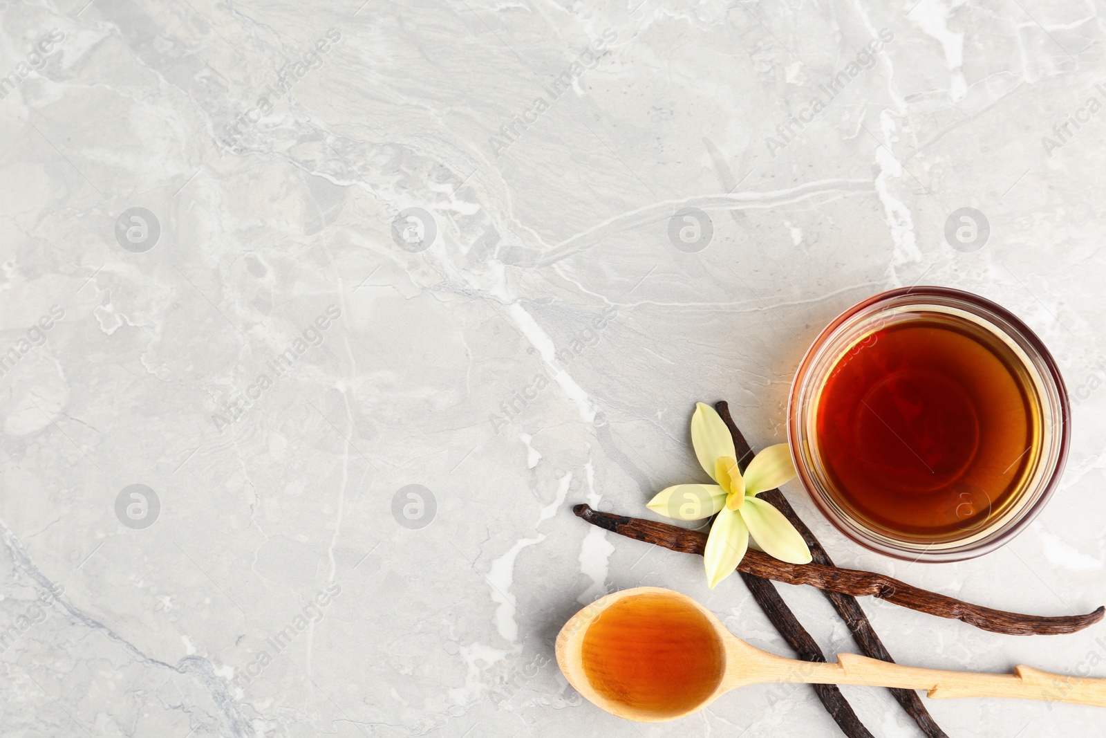 Photo of Flat lay composition with vanilla extract on light grey marble table. Space for text