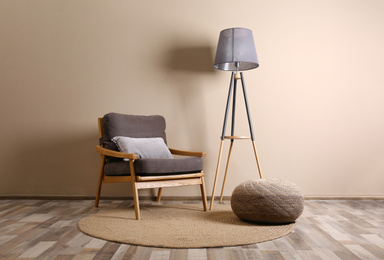 Photo of Comfortable armchair with cushion in stylish room interior