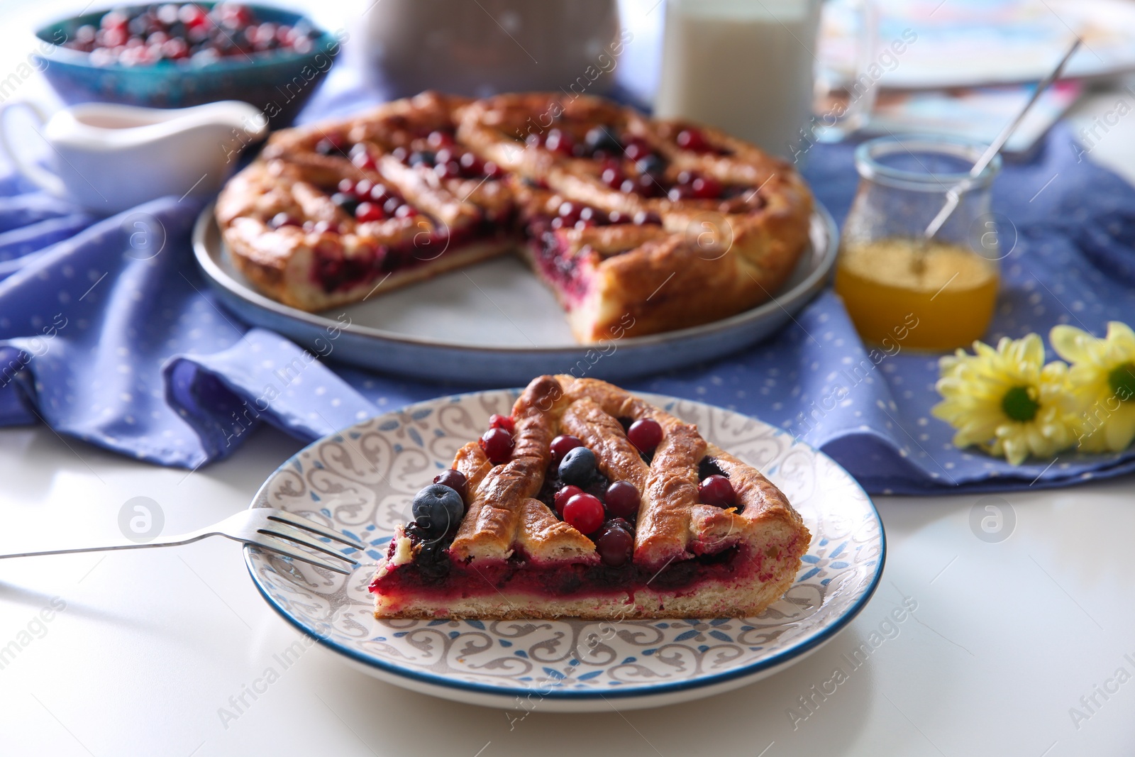 Photo of Piece of delicious currant pie with fresh berries served on white table