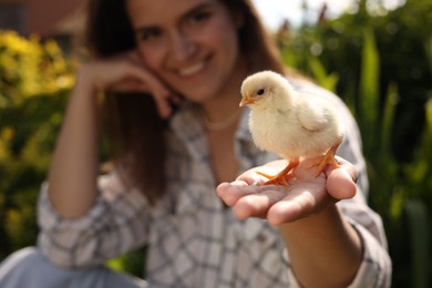 Photo of Woman with cute chick outdoors, selective focus