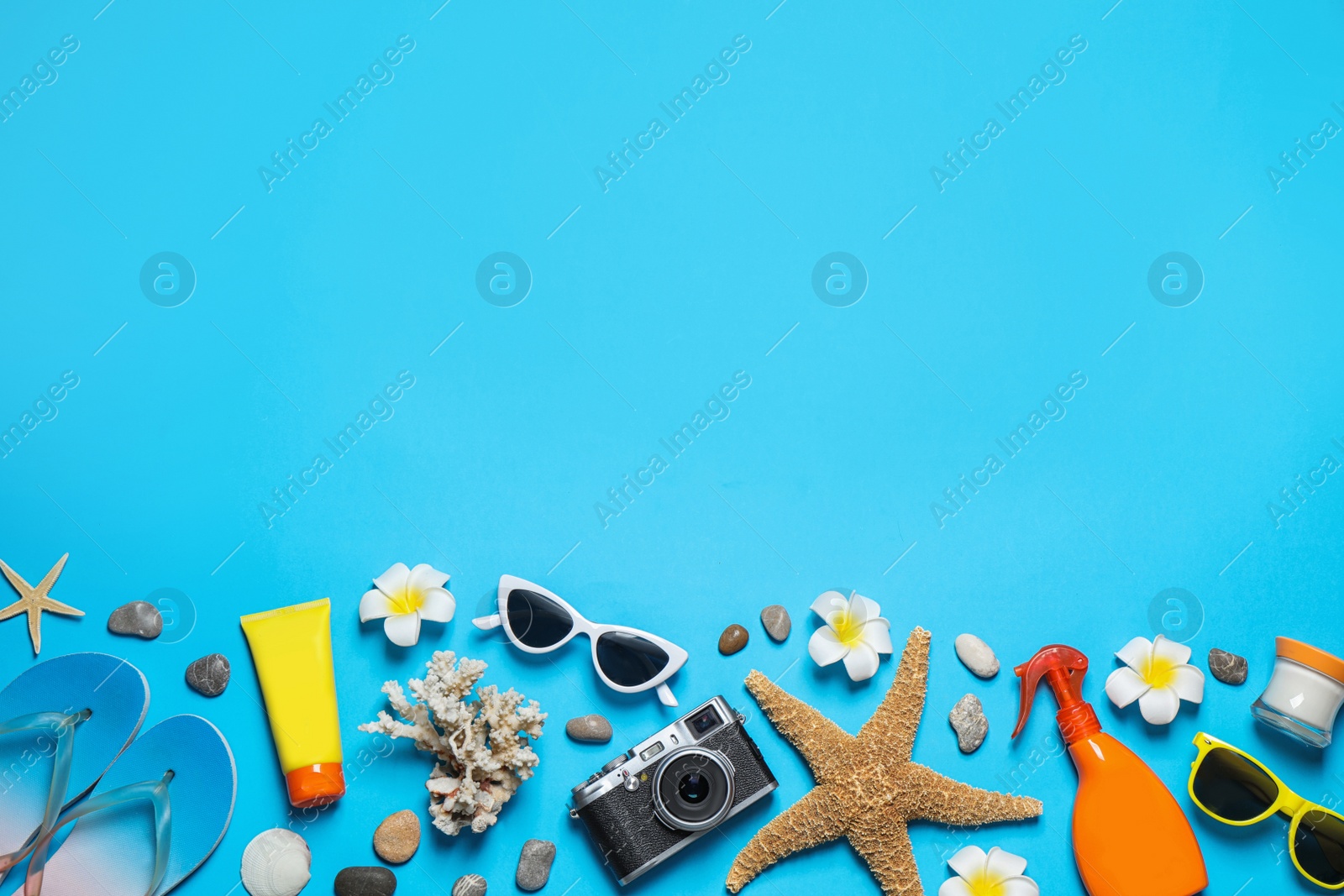 Photo of Flat lay composition with stylish beach accessories on light blue background, space for text