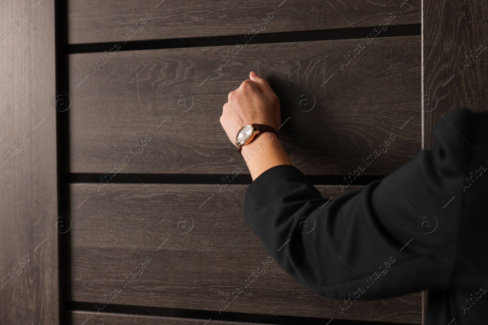 Photo of Collector knocking on door indoors, closeup. Space for text