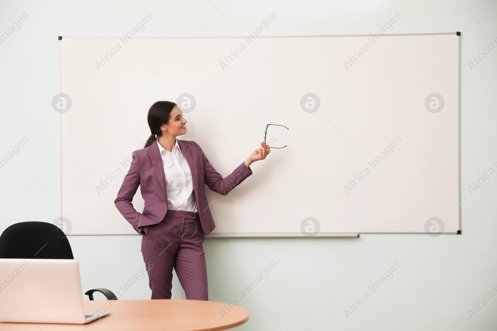 Photo of Female teacher near whiteboard in modern classroom