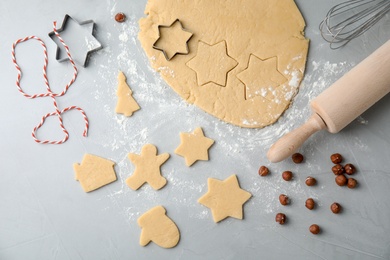 Photo of Flat lay composition with dough and cutters on table, top view. Preparing Christmas cookies