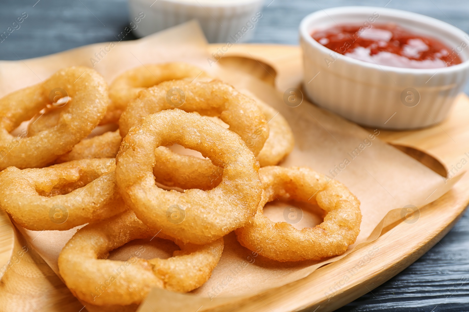 Photo of Fried onion rings served with sauce on plate, closeup