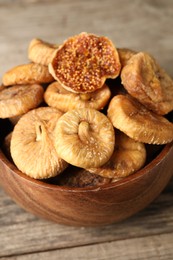 Bowl with tasty dried figs on wooden table, closeup