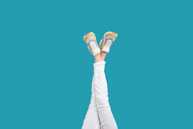 Photo of Woman in stylish sport shoes on light blue background