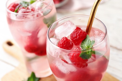 Glass of refreshing drink with raspberry and mint on table, closeup view. Space for text