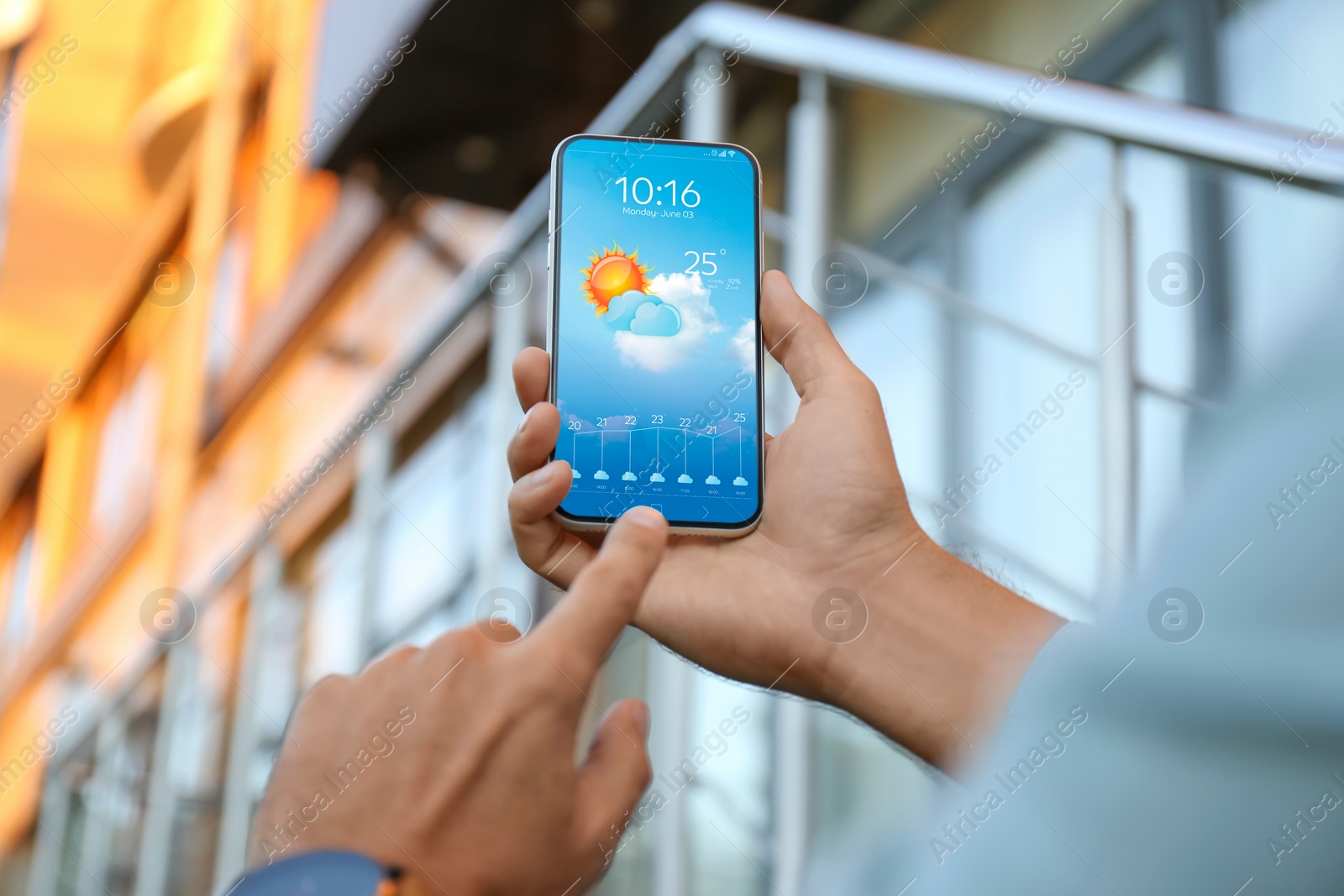 Image of Man checking weather using app on smartphone outdoors, closeup. Data and illustration of sun with cloud on screen