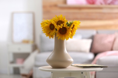 Photo of Beautiful bouquet of sunflowers in vase on white table indoors