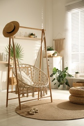 Photo of Comfortable hammock chair in stylish room. Interior design