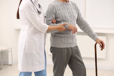 Photo of Nurse supporting elderly patient in hospital, closeup