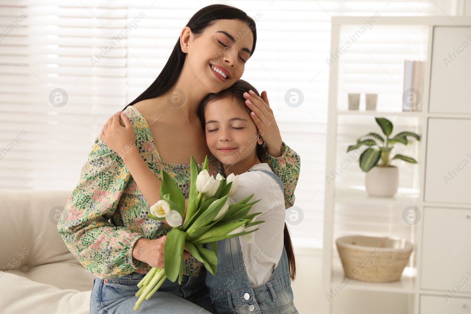 Photo of Little daughter congratulating her mom at home. Happy Mother's Day