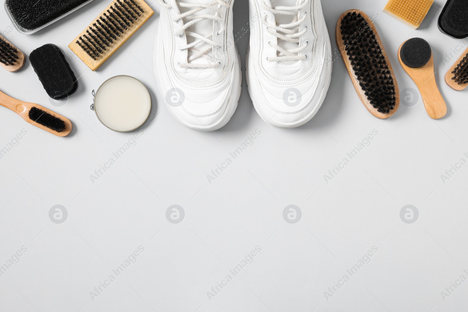 Photo of Flat lay composition with stylish footwear and shoe care accessories on white background, space for text