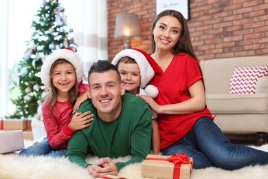 Happy parents and children near Christmas tree at home