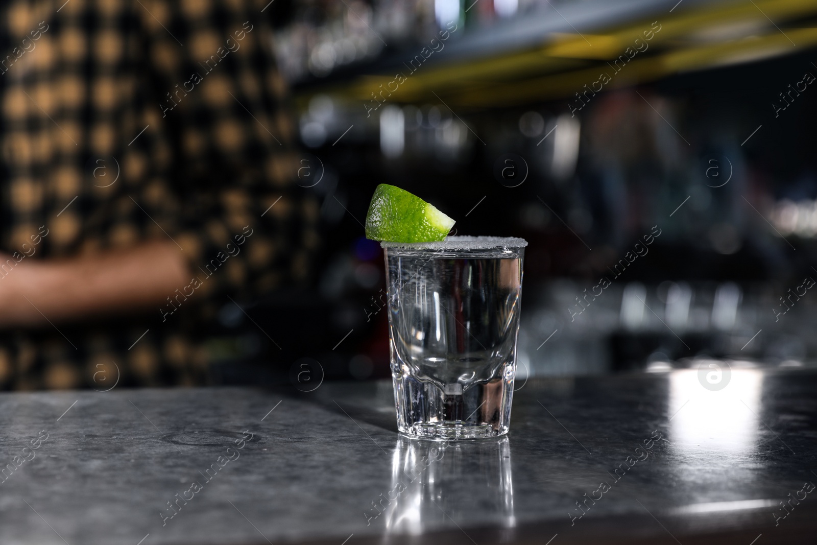 Photo of Mexican Tequila shot with lime slice on bar counter