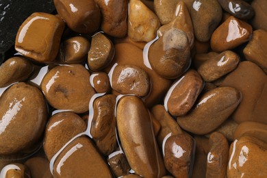 Beautiful pebbles in water as background, top view