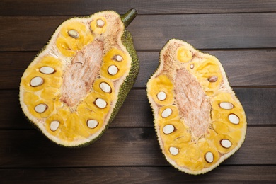 Delicious cut exotic jackfruit on wooden table, flat lay