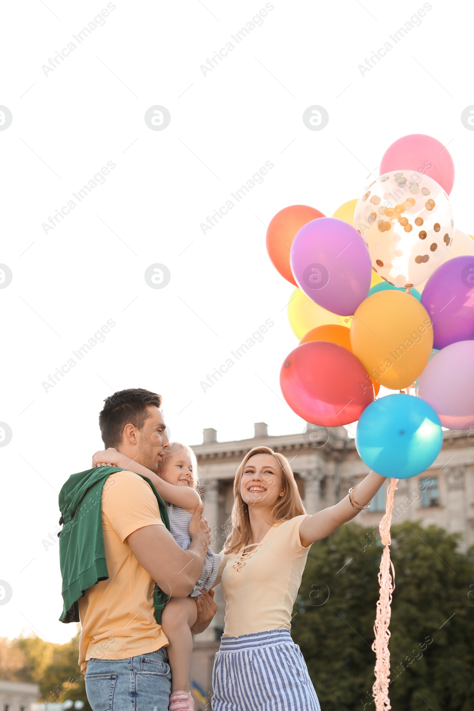 Photo of Happy family with colorful balloons outdoors on sunny day