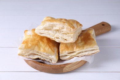 Photo of Delicious puff pastry on white wooden table, closeup