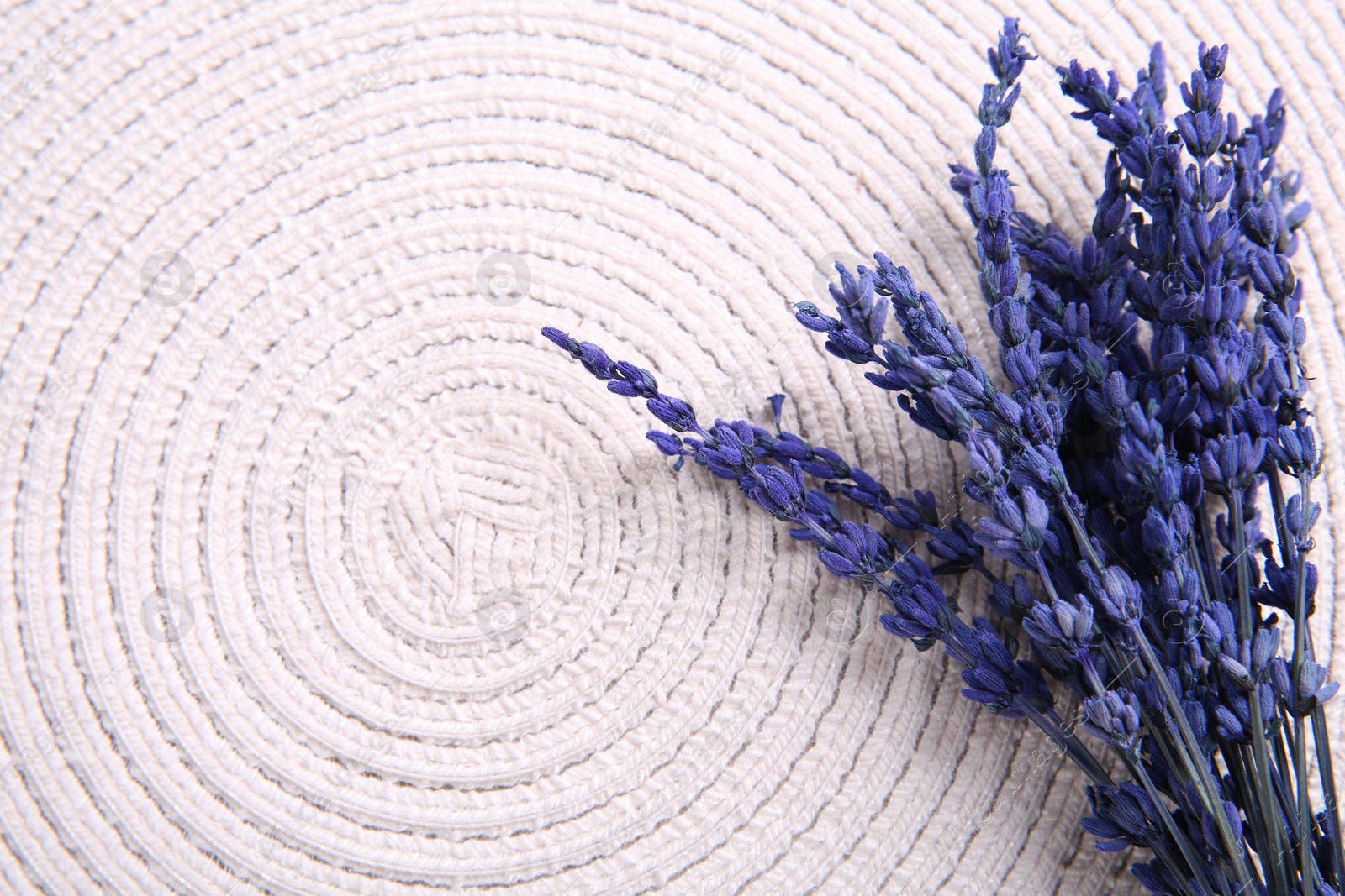 Photo of Bouquet of beautiful preserved lavender flowers on white cotton place mat, top view. Space for text