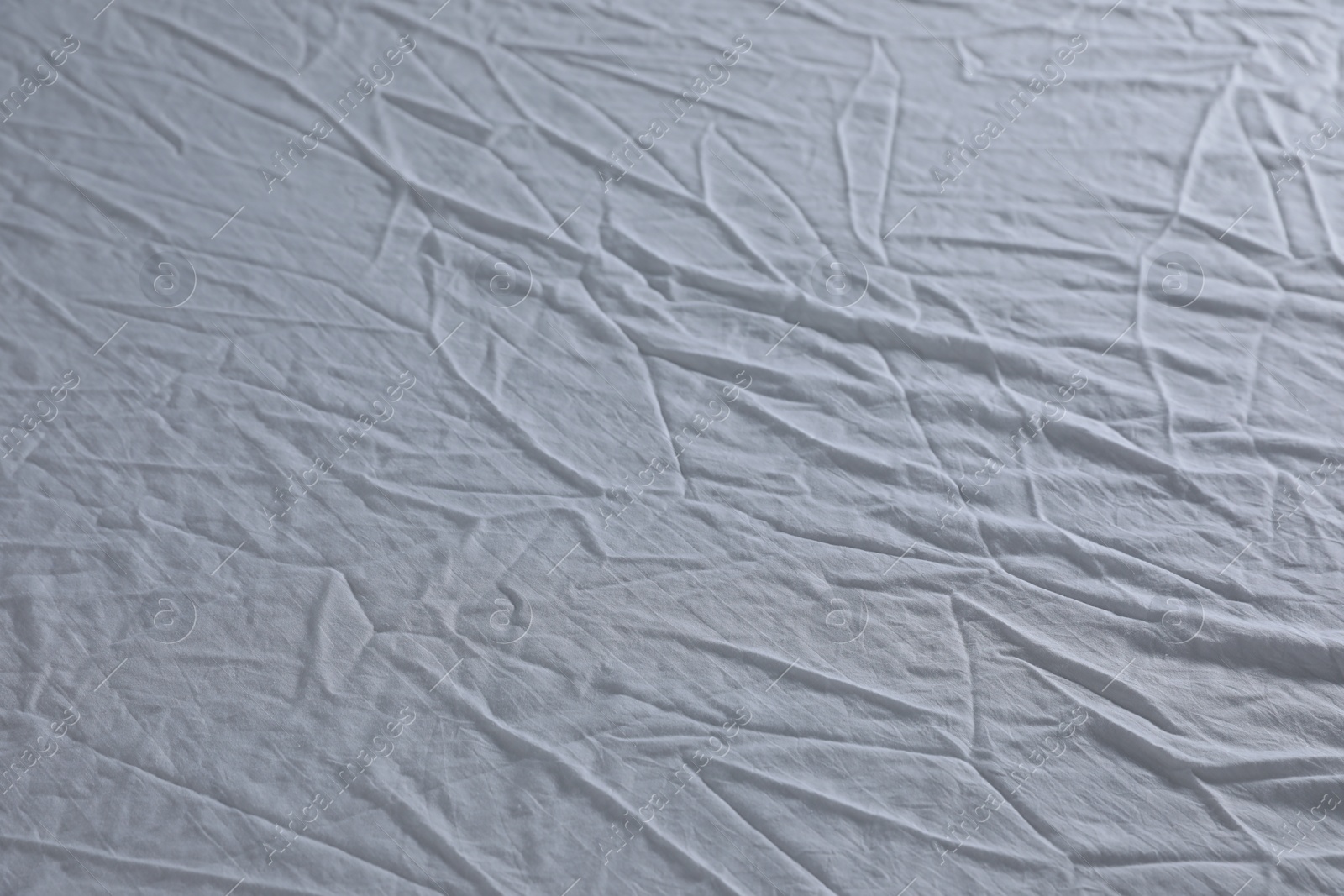 Photo of Crumpled white fabric as background, closeup view