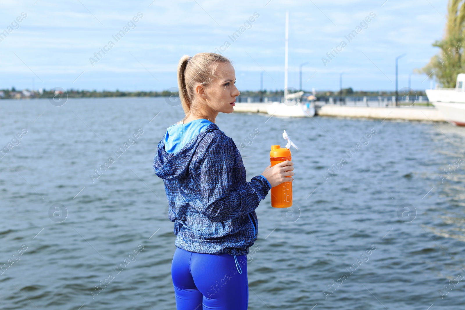 Photo of Woman with bottle of protein shake near river